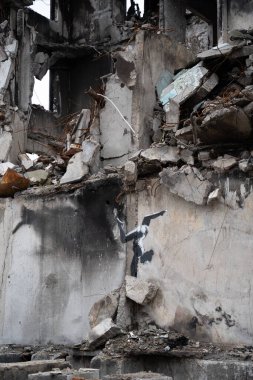Borodyanka, Kyiv bölgesi 11.12.2022. Ukrayna 'da Rusya' nın işgalinden sonra yıkılan bir evin duvarındaki İngiliz sokak sanatçısı Banksy 'nin duvar resmi. Jimnastikçi kız ellerinin üstünde duruyor.