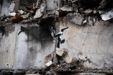 Borodyanka, Kyiv bölgesi 11.12.2022. Ukrayna 'da Rusya' nın işgalinden sonra yıkılan bir evin duvarındaki İngiliz sokak sanatçısı Banksy 'nin duvar resmi. Jimnastikçi kız ellerinin üstünde duruyor.