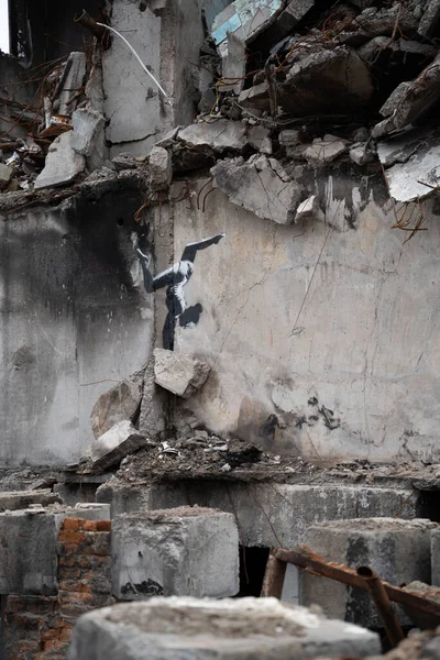 stock image Borodyanka, Kyiv region 11.12.2022 The work of the mural of the British street artist Banksy on the wall of a destroyed house after the invasion of Russia in Ukraine. Gymnast girl stands on her hands