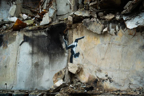Borodyanka, Kyiv bölgesi 11.12.2022. Ukrayna 'da Rusya' nın işgalinden sonra yıkılan bir evin duvarındaki İngiliz sokak sanatçısı Banksy 'nin duvar resmi. Jimnastikçi kız ellerinin üstünde duruyor.