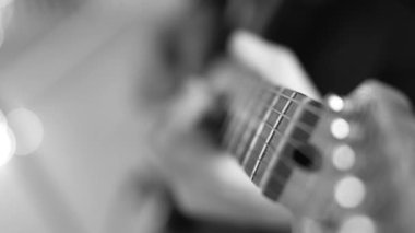 A man plays an electric guitar, closeup view