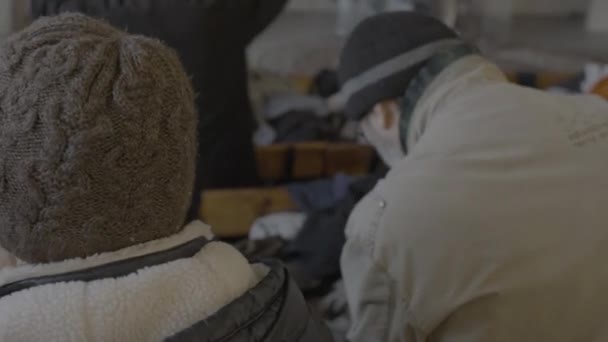 Люди Обирають Одяг Другої Руки Під Час Розподілу Гуманітарної Допомоги — стокове відео