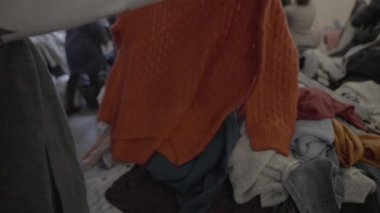 İnsanlar insani yardım dağıtımı sırasında ikinci el giysi seçiyorlar çünkü kriz