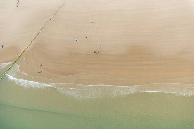 Aileler Barmouth Beach, Gwynedd, Kuzey Galler 'de güneşli bir günün tadını çıkarıyorlar.
