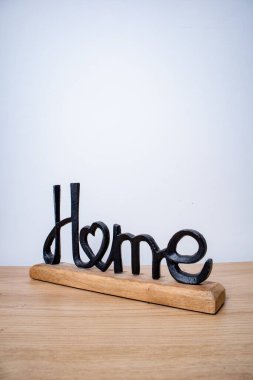 Ev dekoratif bir figür. Beyaz arka planda siyah metal ve ahşaptan yapılmış ev sözcüğü.