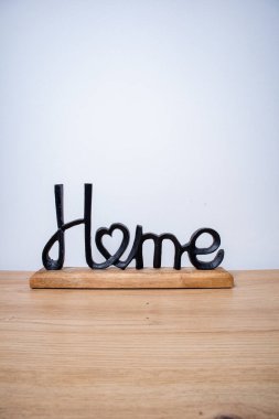 Ev dekoratif bir figür. Beyaz arka planda siyah metal ve ahşaptan yapılmış ev sözcüğü.