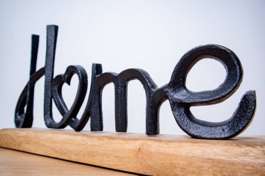 Ev dekoratif bir figür. Beyaz arka planda siyah metal ve ahşaptan yapılmış ev sözcüğü.