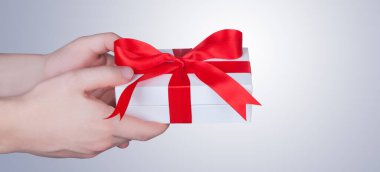 Saten kurdeleyle paketlenmiş bir hediye kutusu. Mutlu Noeller..