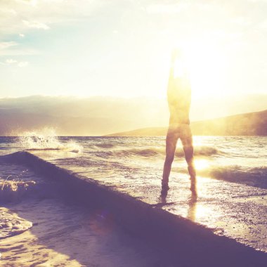 Özgürlük duygusu konsepti. Kadın büyük dalgalarla denize bakan iskelede zıplıyor.