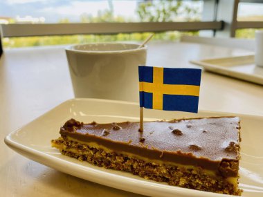 Üstünde İsveç bayrağı olan bir dilim pasta. Ikea Restoranı