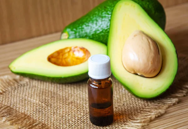 stock image Avocado and avocado oil on wooden background. Selective focus.food