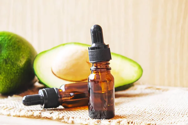 stock image Avocado and avocado oil on wooden background. Selective focus.food