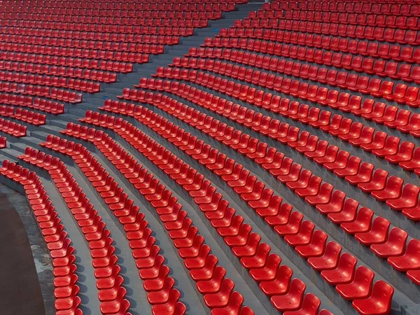 Red seats on stadium steps bleacher with spot light pole, bright red stadium seats