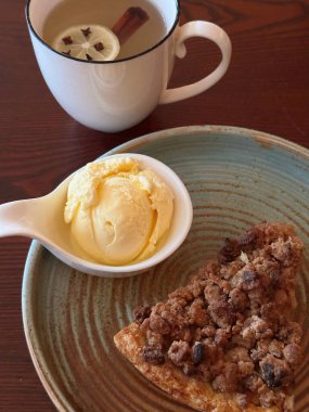 Apple Crumble Dessert with vanilla ice cream on Rustic Wooden Surface