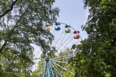 Dönme dolap üzerinde mavi bulutlu gökyüzü arka planda eğlenceli bir parçası park.