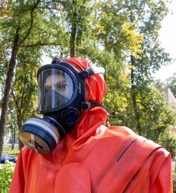 Koruma giysisi ve gaz maskesi giyen profesyonel bir işçi.