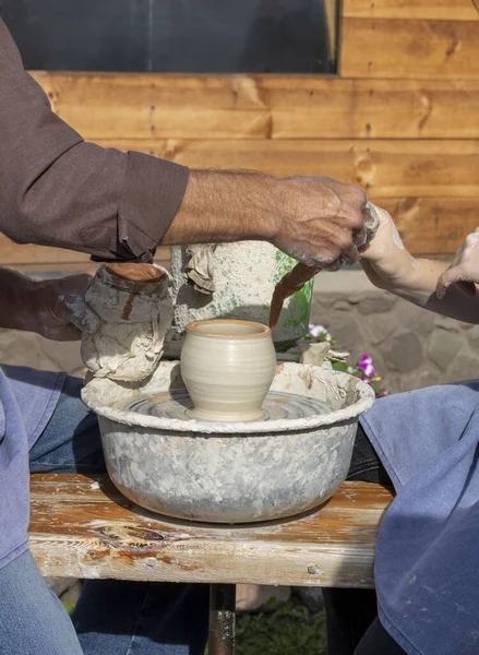 Master Potter teaches how to sculpt a clay pot under a potter\'s wheel. Ceramics. Cultural traditions. Self made. Craft
