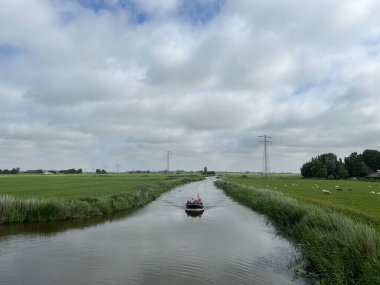 Hollanda, Friesland 'daki Achlum çevresinde bir kanalda tekne.