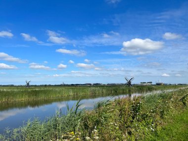 Hollanda, Friesland 'daki Leeuwarden çevresindeki kanalın yanındaki Mills.