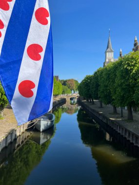 Frisian flag at the canal in Sloten, Friesland the Netherlands clipart