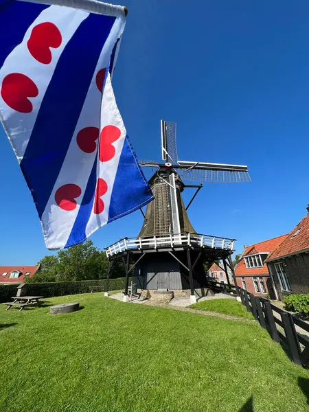 オランダのフリースランド州スローテンにある風車のフリジアの旗 ストック画像