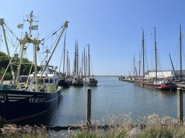 Fisher boat and sailboats in the harbor of Stavoren in Friesland the Netherlands clipart
