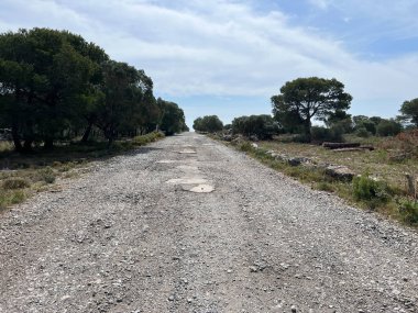 Gravel road through nature reserve around L Escala and L Estartit in Catalonia, Spain clipart