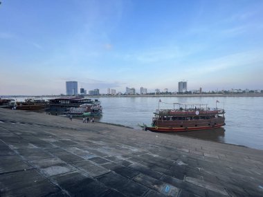 Kamboçya Phnom Penh bulvarında nehir boyunca tekneler.