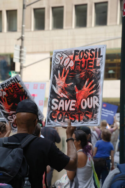 New York, NY - September 17, 2023: African American protester with rising sea level sign at march against fossil fuel rally
