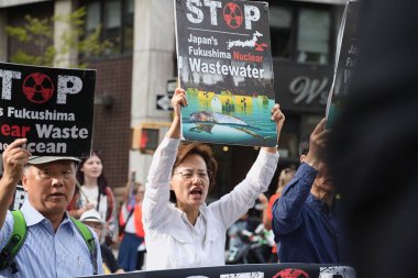 New York, New York - 17 Eylül 2023: Kızgın Asyalı protestocular ellerinde Fukushima 'nın Pasifik Okyanusu' na radyoaktif atık su salınımını durdurmak için tabelalar tutarken yürüdüler  