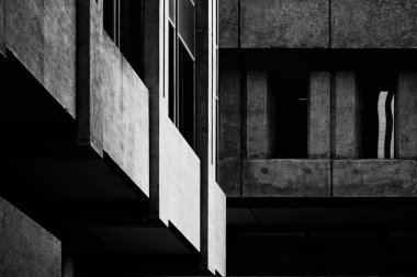 Siyah ve beyaz, yüksek kontrastlı güzel sanatlar, soyutlanmış iki beton bina, acımasız mimari tarzıyla inşa edilmiş. Güneş ışığının yan yana gelmesi köşegen ve düz bloklar gölgede. 
