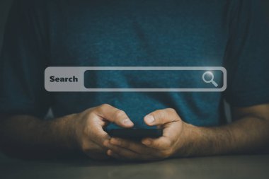 İş adamı boş arama çubuğu ile internet veri bilgilerine göz atmak için cep telefonu araması yapıyor. Arama motoru optimizasyonu SEO ağ konsepti. İş adamı masasında akıllı telefonla çalışıyor..