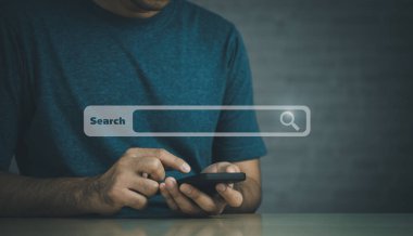 İş adamı boş arama çubuğu ile internet veri bilgilerine göz atmak için cep telefonu araması yapıyor. Arama motoru optimizasyonu SEO ağ konsepti. İş adamı masasında akıllı telefonla çalışıyor..