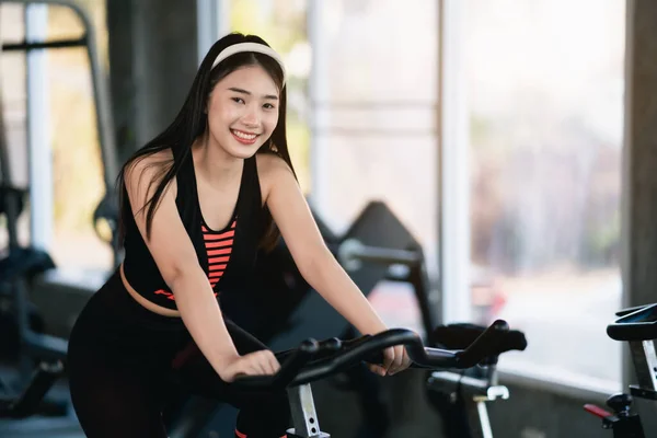 亚洲女运动员在健身房骑自行车锻炼 决心要进行有氧运动 这让她变得健康 运动自行车女健美运动概念 — 图库照片