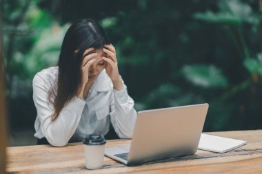 Asyalı serbest çalışan kadın evde dizüstü bilgisayarla çalışırken stresli depresyon geçiriyor. Bunalımlı kadın üzgün ciddi evde çalışıyor. Herhangi bir yerde çalışma kavramı.