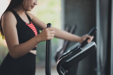 Spor salonunda eliptik makine üzerinde egzersiz yapan Asyalı sporcu kadın kilo verme azmi, onu sağlıklı yapıyor. egzersiz eliptik makine kadın spor konsepti.