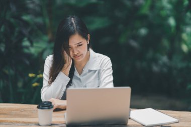 Asyalı serbest çalışan kadın evde dizüstü bilgisayarla çalışırken stresli depresyon geçiriyor. Bunalımlı kadın üzgün ciddi evde çalışıyor. Herhangi bir yerde çalışma kavramı.