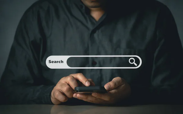 İş adamı boş arama çubuğu ile internet veri bilgilerine göz atmak için cep telefonu araması yapıyor. Arama motoru optimizasyonu SEO ağ konsepti. İş adamı masasında akıllı telefonla çalışıyor..