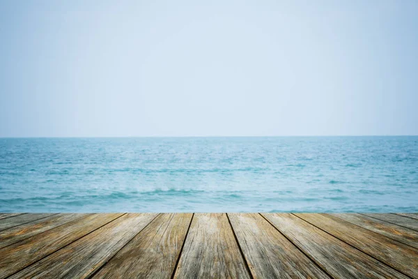 热带沙滩地平线上的木地板前景广阔 淡淡的蓝海背景 带着淡淡的暑假 阳光照耀着甲板 阳光照射着阳光 天空冲浪着夏云的概念 — 图库照片