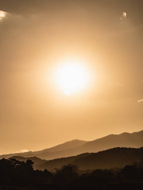 Dağ ve altın sarısı güneşli güneş manzaralı gün batımı. Dağlarda canlı, renkli bir akşam gökyüzü altında. Doğa dağı gökyüzü ve bulutlar günbatımı konsepti