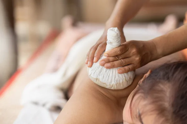 Massage spa relaxing treatment of office syndrome traditional thai massage style. Asian female massage traditional compress for hot massage back pain, arm pain and stress for woman tired from work.
