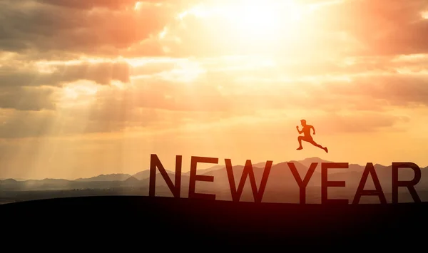 Sport man run jump happy new year 2023 concept, silhouette of man jumping over barrier cliff and success with beautiful sunset background. Happy New Year 2023 use for web banner and advertisement.
