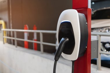 EV şarj istasyonu EV bataryası için. Elektrikli motoru olan bir araç için fiş. EV şarj aleti. Temiz enerji. Otoparkın şarj noktası. Gelecekteki ulaşım teknolojisi modern araba konsepti.