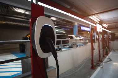 EV şarj istasyonu EV bataryası için. Elektrikli motoru olan bir araç için fiş. EV şarj aleti. Temiz enerji. Otoparkın şarj noktası. Gelecekteki ulaşım teknolojisi modern araba konsepti.