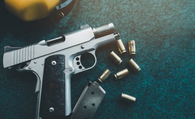 Üst manzara, düz tabanca mermileri ve kağıt atış talimi hedefinde kulaklıkları iptal eden sarı ses. Atış taliminden sonra atış poligonunda. Spor atış konsepti.
