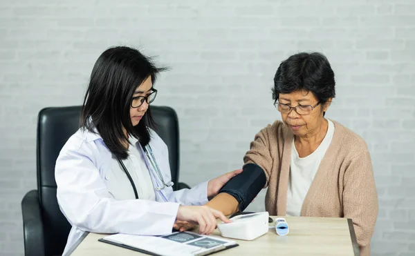 Ärztin Misst Blutdruck Bei Älteren Patientinnen Auf Dem Schreibtisch Des — Stockfoto