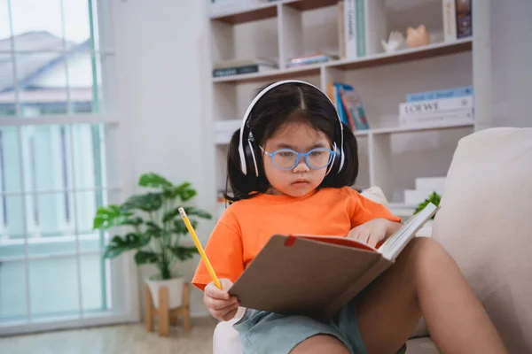 Asiatiska Baby Flicka Barn Bär Glasögon Och Hörlurar Skriva Anteckningar — Stockfoto