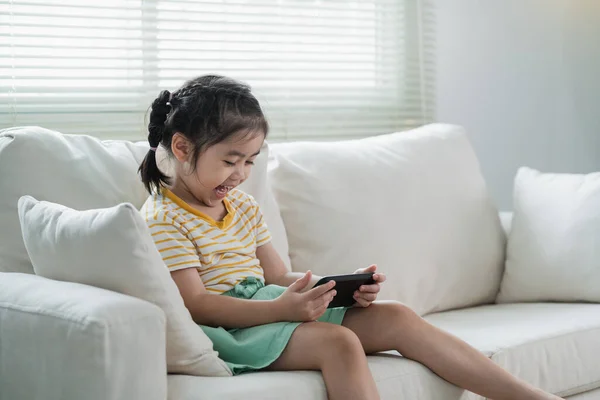 Kanepede Cep Telefonu Ekranı Kullanan Dokunan Asyalı Kız Çocuğu Bebek — Stok fotoğraf