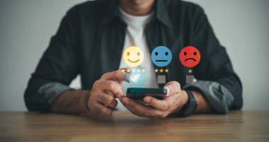 Cep telefonu kullanan kullanıcı, online başvuru puanındaki hizmet deneyimine derecelendirme verir, Müşteri memnuniyeti geri bildirim anketi konsepti, itibar sıralamasına öncülük eden kalite servisinin değerlendirilmesi.