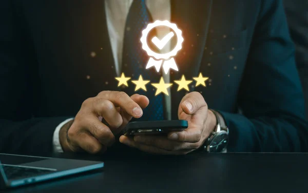 Businessman use smart phone virtual icon providing a five-star premium service. mobile showing award high standards are guaranteed, service quality, the assurance five stars. Guarantee the quality.